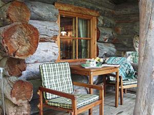 - une table et des chaises en bois dans une cabane en rondins dans l'établissement Holiday Home Alppimaja by Interhome, à Pätiälä