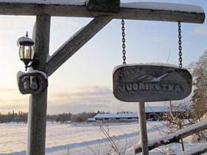a sign hanging from a chain in a snow covered field at Holiday Home Villa vuorikotka by Interhome in Kaivanto