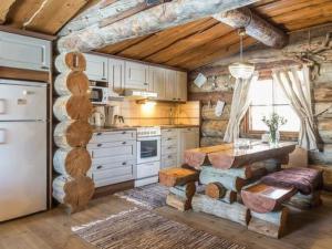 a kitchen with a table and a refrigerator at Holiday Home Kopinkallio 3 by Interhome in Pätiälä