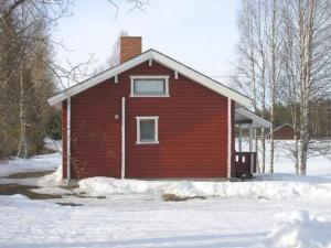 a red house with snow in front of it at Holiday Home Hilla by Interhome in Jokijärvi