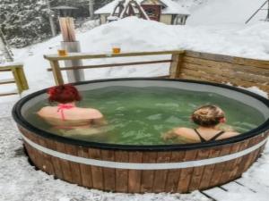 two women in a hot tub in the snow at Holiday Home Rantamaja by Interhome in Kittilä