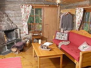 sala de estar con sofá rojo y chimenea en Holiday Home Divaanikivi by Interhome, en Pätiälä