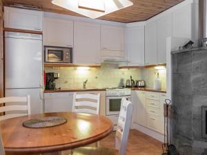 アカスロンポロにあるHoliday Home Kuerkartano 1-onni by Interhomeのキッチン(木製テーブル、白いキャビネット付)