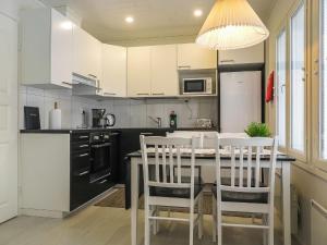 a kitchen with white cabinets and a table and chairs at Holiday Home Kuukkeli by Interhome in Kyrö +13 photos