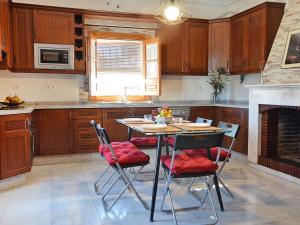 a kitchen with a table and chairs and a fireplace at Holiday Home Torreon de Morayma by Interhome in Baena