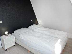 ノールトウェイクにあるHoliday Home de Witte Raaf-2 by Interhomeのベッド(白いシーツ、ランプ2つ付)