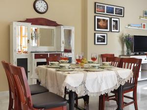 a dining room table with wine glasses and a clock at Holiday Home Torreon de Morayma by Interhome in Baena