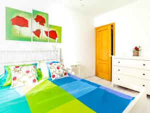 a bedroom with a colorful bed and a dresser at Apartment Edif- museo 2ºk by Interhome in Torre de Benagalbón