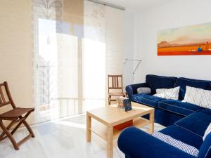 un soggiorno con divano blu e tavolo di Apartment Edif- Museo 2ºk by Interhome a Torre de Benagalbón