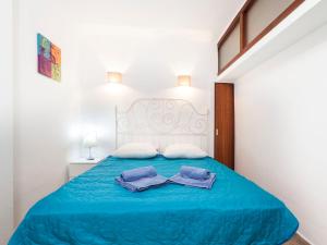 - une chambre avec un lit bleu et des serviettes dans l'établissement Apartment Fanals-8 by Interhome, à Platja d'Aro