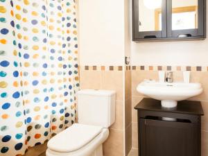 a bathroom with a toilet and a sink and a shower curtain at Apartment Edif- museo 2ºk by Interhome in Torre de Benagalbón +3 photos