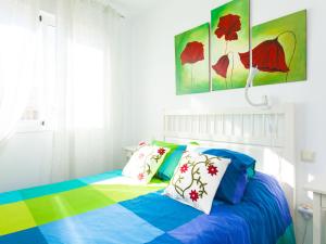 a bed with colorful sheets and pillows in a room at Apartment Edif- Museo 2ºk by Interhome in Torre de Benagalbón
