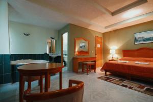 - une chambre avec un lit et une table ainsi qu'une salle de bains dans l'établissement HOTEL EL CONQUISTADOR MONARCA., à Zitácuaro