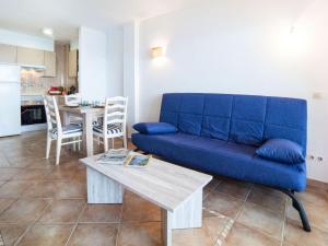 a living room with a blue couch and a table at Apartment Vermell-8 by Interhome in Platja  d'Aro