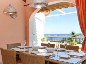ein Esszimmer mit einem Tisch und einem großen Fenster in der Unterkunft Villa Villa Da Vinci by Interhome in Monte Pego