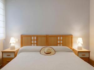 デニアにあるApartment La Riviera by Interhomeのベッド(ランプ2つ付)に座る帽子