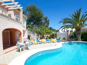eine Villa mit Swimmingpool und Palmen in der Unterkunft Villa Amber by Interhome in Calpe