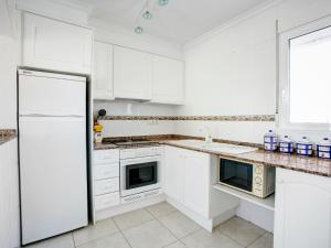 uma cozinha branca com armários brancos e um frigorífico em Apartment La Giralda by Interhome em Denia