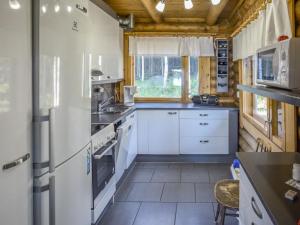 a kitchen with white appliances and a wooden ceiling at Holiday Home Leporanta by Interhome in Herttuala