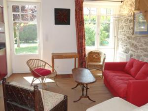 sala de estar con sofá rojo y sillas en Holiday Home La Rodière by Interhome en Saint-Lunaire