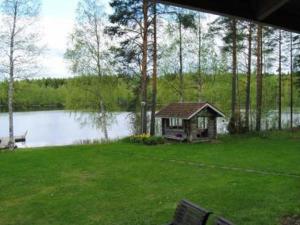 einen Pavillon in einem Hof neben einem See in der Unterkunft Holiday Home Köökuu by Interhome in Heinäkylä
