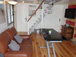 a living room with a leather couch and a glass table at Chalet Le Bois d'Amour by Interhome in Dinard