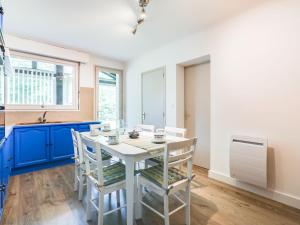 una cocina con armarios azules y una mesa y sillas blancas. en Holiday Home Mauriac by Interhome, en Soorts-Hossegor