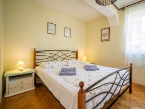 a bedroom with a bed and a table and a window at Holiday Home Zora by Interhome in Njivice