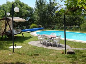 a table and chairs next to a swimming pool at Holiday Home Ca' di Bacco-2 by Interhome in Nestore