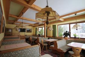 a restaurant with tables and chairs and a large window at Pension Hubertushof beim Römerbad in Bad Kleinkirchheim