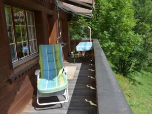 twee ligstoelen op een veranda van een huis bij Apartment Marmotte- Chalet by Interhome in Lauenen