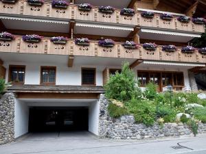 - un bâtiment avec un balcon fleuri dans l'établissement Apartment Drive - Nr- 3 by Interhome, à Gstaad