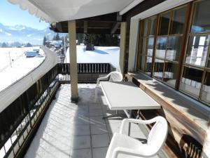 ザーネンメサーにあるApartment Media by Interhomeの白いテーブルと椅子(雪のあるバルコニー)
