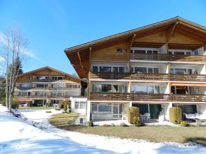 een groot appartementencomplex met sneeuw op de grond bij Apartment La Sarine 124 by Interhome in Gstaad