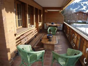- une terrasse couverte avec des chaises et une table sur un balcon dans l'établissement Apartment Drive - Nr- 3 by Interhome, à Gstaad
