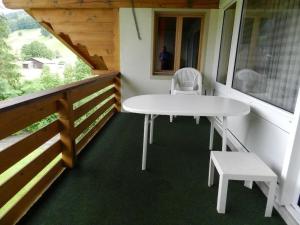 a white table and a chair on a porch at Apartment La Sarine 324 by Interhome in Gstaad