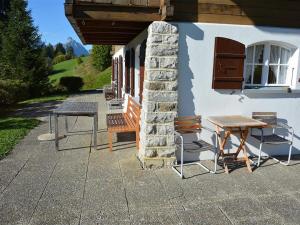 stół i krzesła siedzące poza budynkiem w obiekcie Apartment La Ruche- Chalet by Interhome w mieście Gstaad