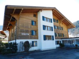 een groot houten gebouw met veel ramen bij Apartment La Sarine 124 by Interhome in Gstaad