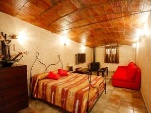 ein Schlafzimmer mit einem Bett und einem roten Stuhl in der Unterkunft Holiday Home L'Aldea by Interhome in L'Aldea