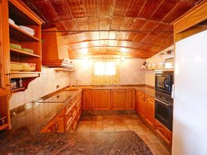 uma grande cozinha com armários de madeira e uma janela em Holiday Home L'Aldea by Interhome em L'Aldea