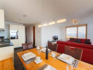 a living room with a table and a red couch at Apartment Apartmenthaus Riederhoru A 1- OG Ost by Interhome in Riederalp