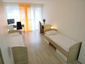 a room with two beds and a desk with a television at Apartment BHMS City Campus by Interhome in Luzern