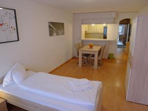 a bedroom with a white bed and a table at Apartment Classic by Interhome in Luzern
