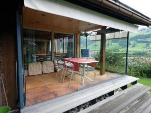 a house with a deck with a table and chairs at Apartment Weidli- Chalet by Interhome in Zweisimmen