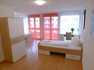a bedroom with a bed and two large windows at Apartment Classic by Interhome in Luzern