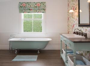 ein Badezimmer mit Badewanne und Fenster in der Unterkunft Laurella Cottage in Blenheim