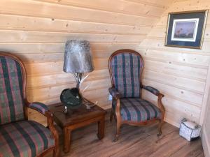 2 sillas y una lámpara en una mesa en una habitación en Dartmoor Cottage, en Steninge