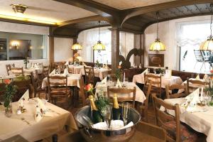 a dining room with tables and chairs with white tablecloths at Hotel Pohl in Kinheim