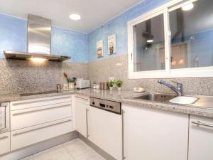 eine Küche mit weißen Schränken und blauen Wänden in der Unterkunft Apartment Nautic by Interhome in Platja  d'Aro