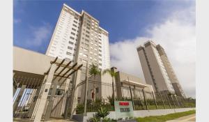 Dois edifícios altos com uma cerca à frente. em Perto Aeroporto Salgado Filho e Arena do Grêmio em Porto Alegre